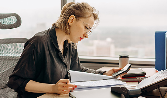 encaissement facture : femme du service facturation qui étudie les éléments des factures en cours